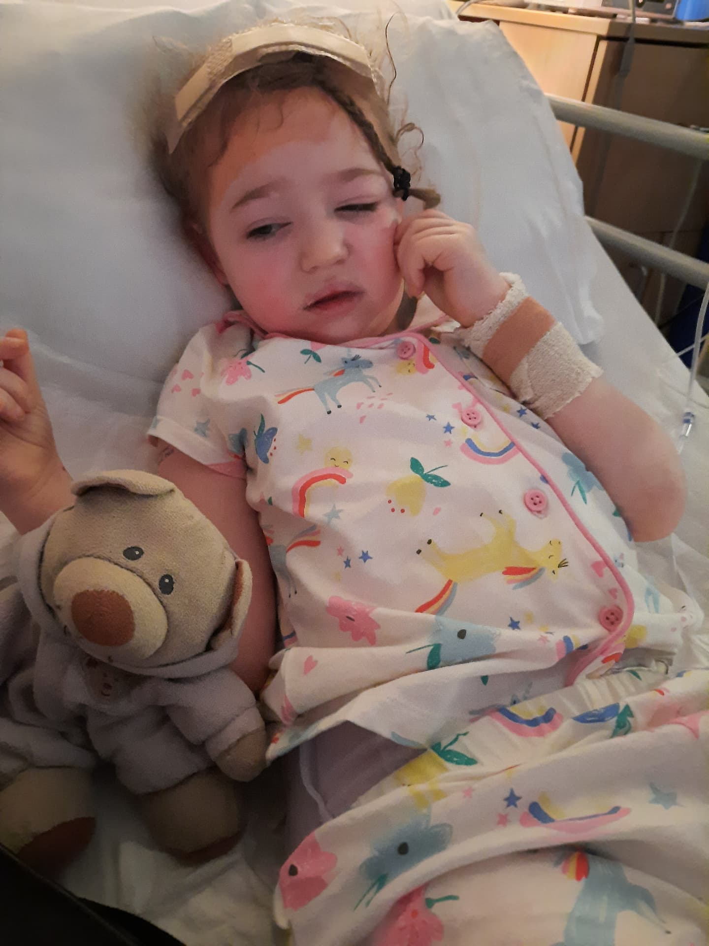 Olivia recovering with teddy after brain surgery